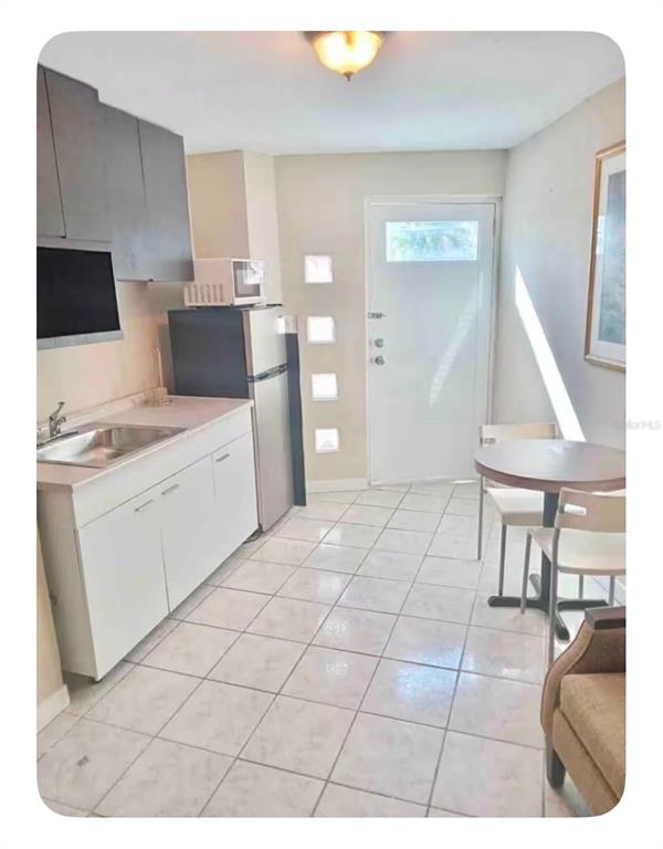 A kitchen with white cabinets, a stainless steel sink, a refrigerator, and a dining table — 274 CALLE PINTA UNIT 1A, SAN JUAN, PR