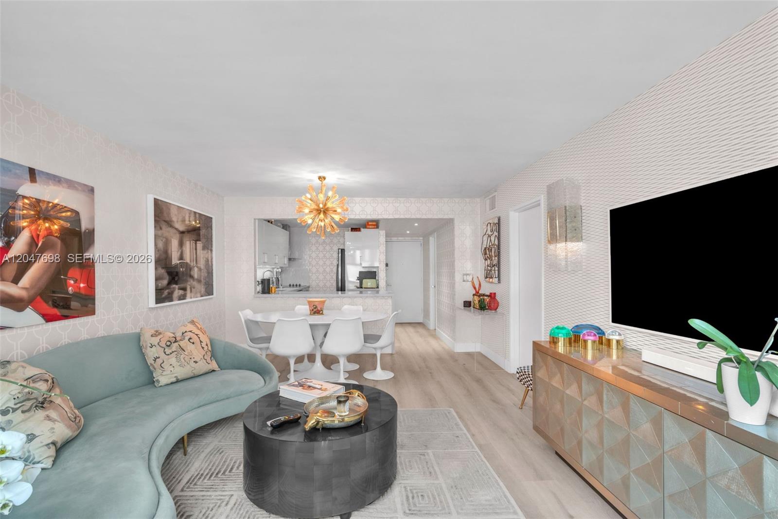 A living room features a curved teal sofa, a round coffee table, and a dining area — 1228 West Ave # 1213, Miami Beach FL 33139, MIAMI BEACH, FL