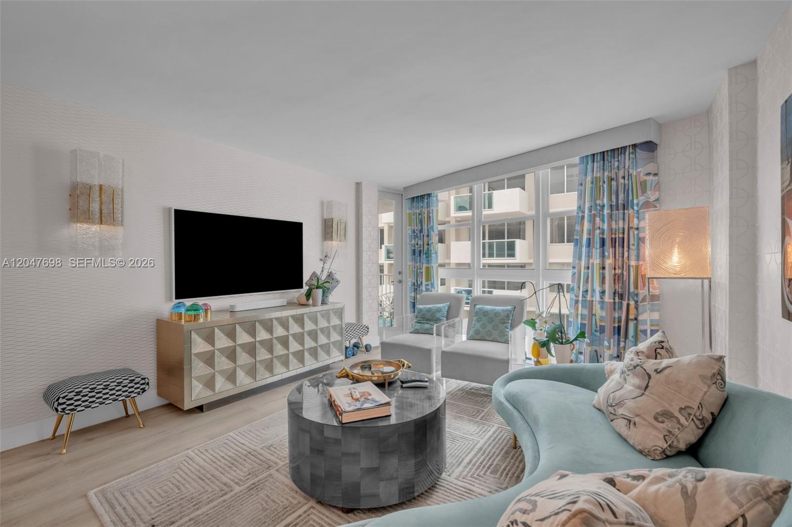 A living room features a curved sofa, a round coffee table, and a geometric media console — 1228 West Ave # 1213, Miami Beach FL 33139, MIAMI BEACH, FL