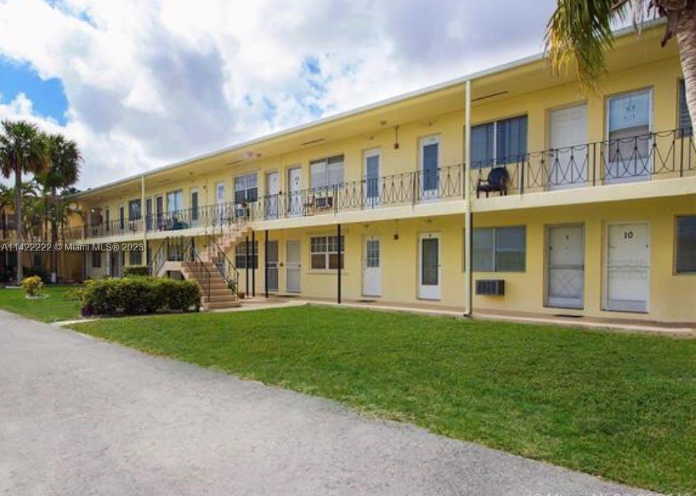 A two-story yellow apartment building with exterior walkways and metal railings — 71 NW 76th St # 16, Miami FL 33150, MIAMI, FL