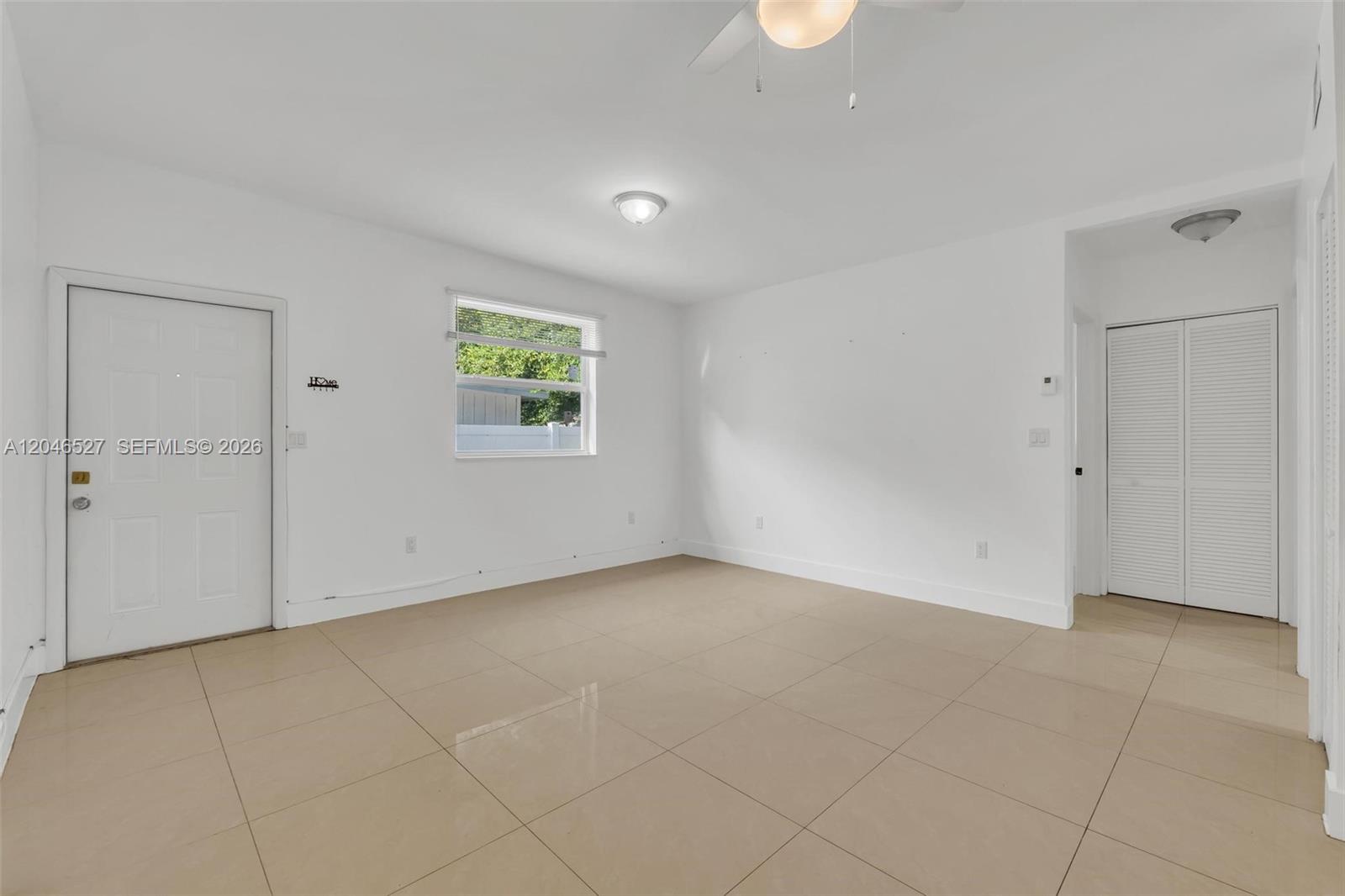 An empty room features white walls, beige tile flooring, a window, and a closet — 7537 NW 3rd Ave # 2, Miami FL 33150, MIAMI, FL