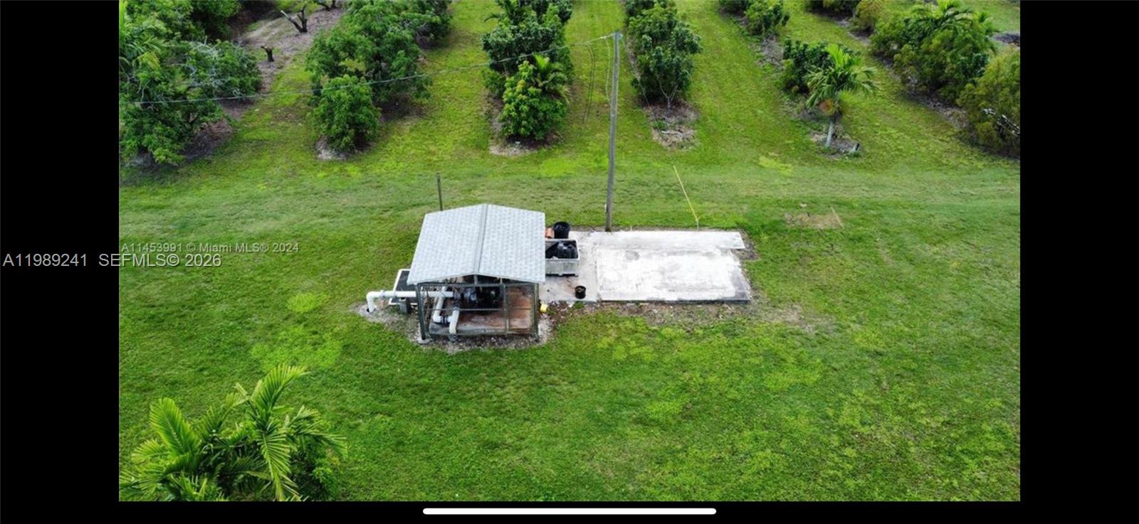 An aerial view shows a small shed with a metal roof next to a concrete pad — xxxxx SW 184 st, Miami FL 33187, MIAMI, FL