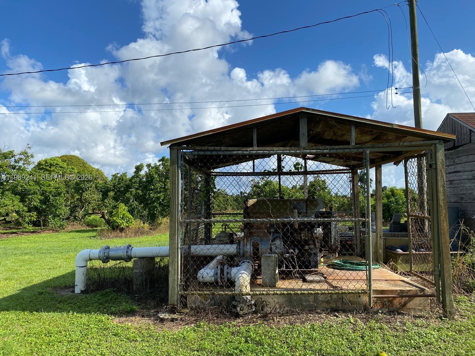 An outdoor pump station sits inside a chain-link enclosure with a metal roof — xxxxx SW 184 st, Miami FL 33187, MIAMI, FL