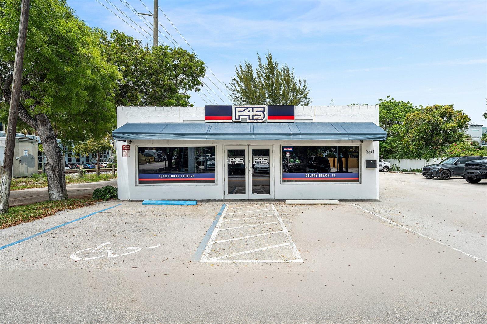 The exterior of a white, single-story commercial building features an F45 fitness studio sign — 301 NE 1st Street, Delray Beach FL 33483, DELRAY BEACH, FL