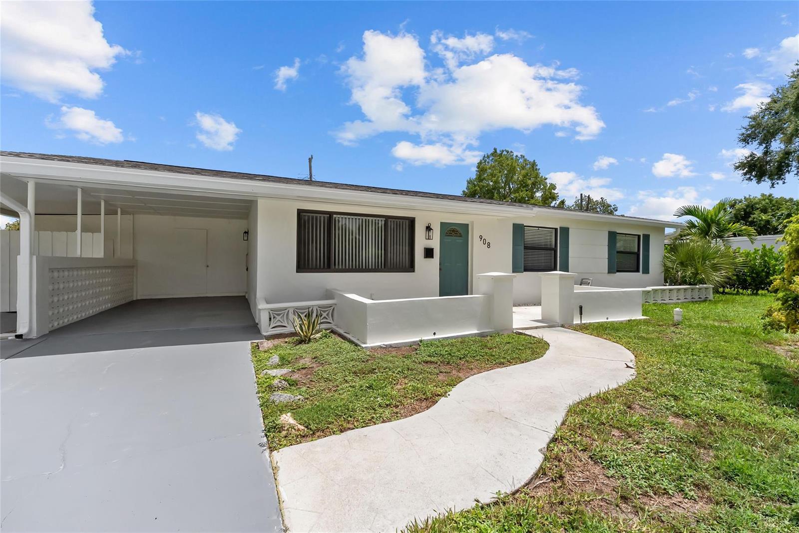 A single-story white house features a carport, a front patio, and a curved concrete walkway — 908 Lighthouse Drive, North Palm Beach FL 33408, NORTH PALM BEACH, FL