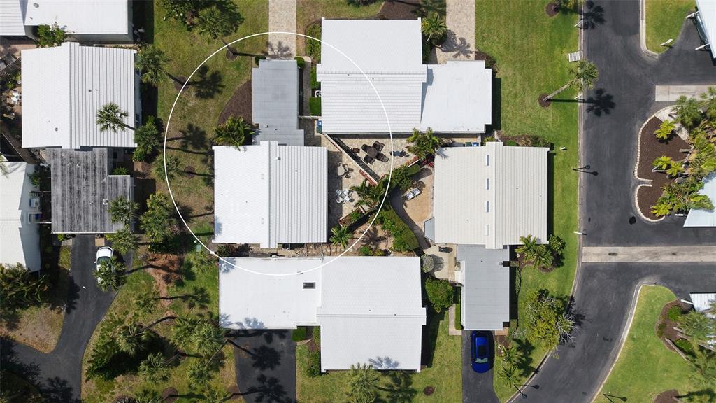A white single-story house features a garage, a covered entryway, and surrounding palm trees — 206 HOURGLASS WAY UNIT V10, SARASOTA, FL