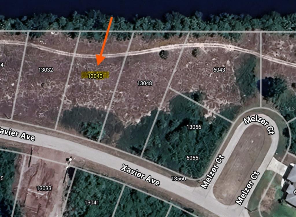 This is an aerial map view of a vacant residential lot highlighted by an arrow — 13040 XAVIER AVENUE, PORT CHARLOTTE, FL