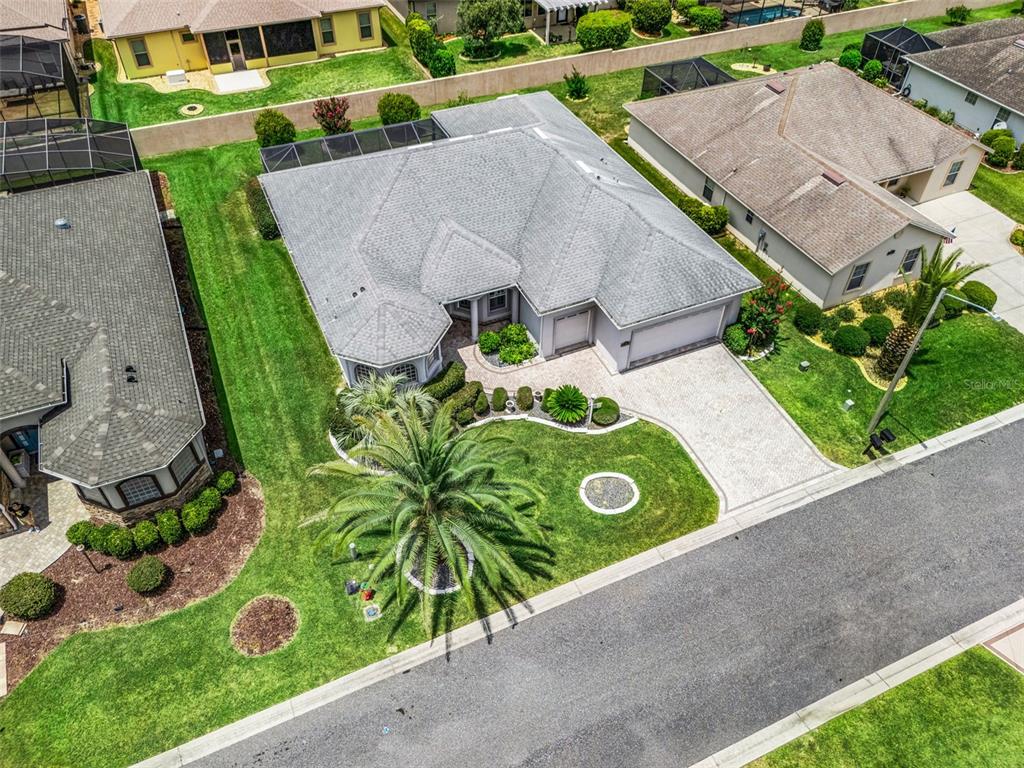 An aerial view shows a suburban house with a gray roof, paved driveway, and landscaping — 16887 SE 110TH COURT ROAD, SUMMERFIELD, FL