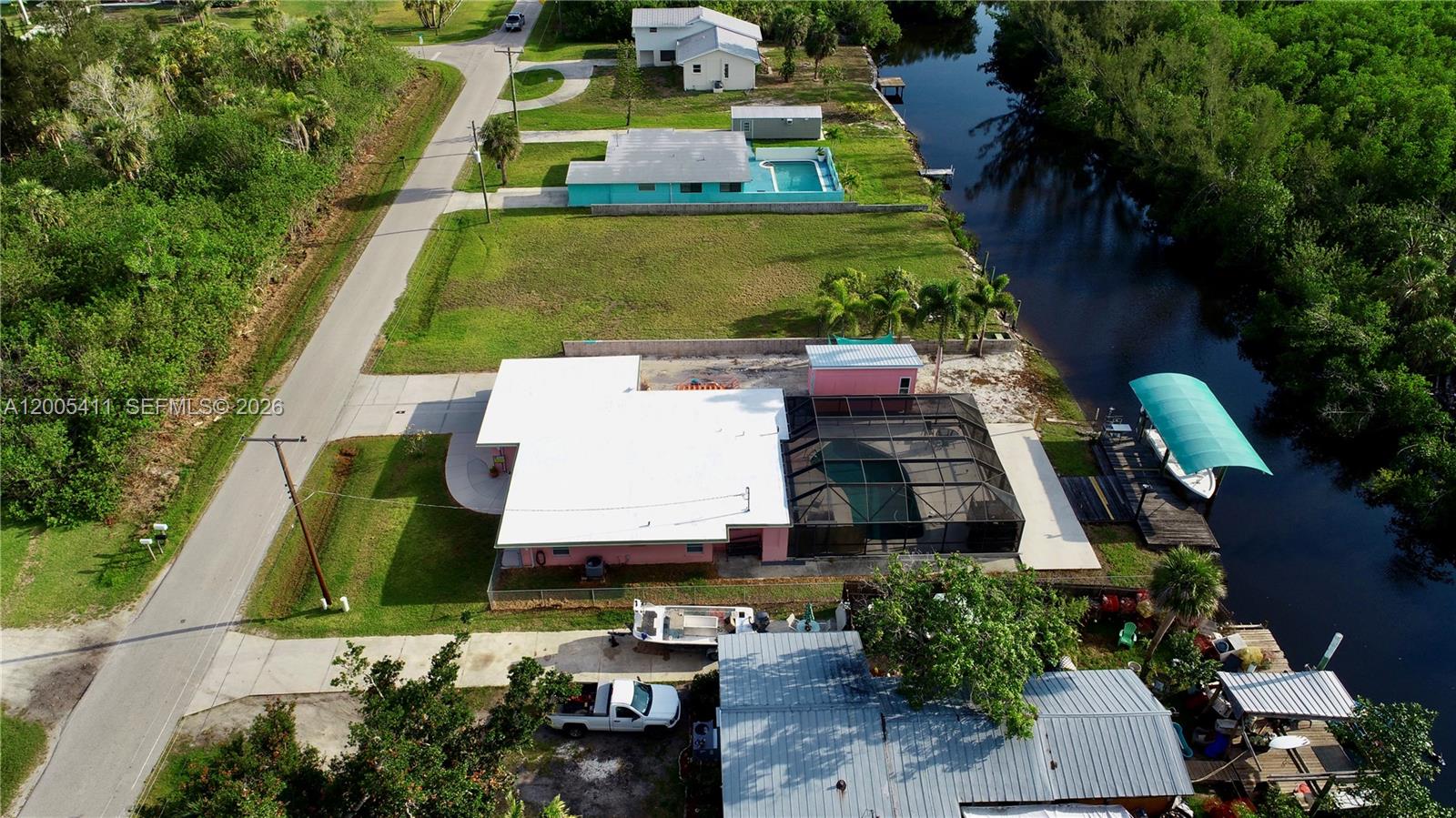 An aerial view shows several waterfront houses with pools and docks along a canal — 232 DARST AVE, Punta Gorda FL 33950, PUNTA GORDA, FL