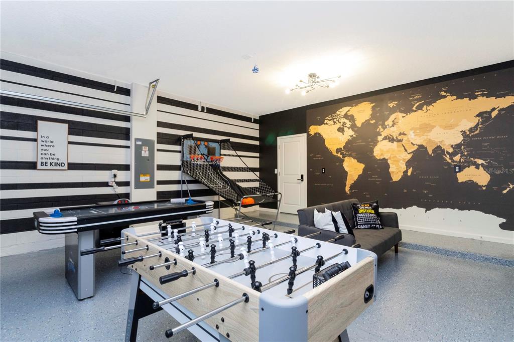 A game room features a foosball table, air hockey table, basketball game, and world map mural — 2569 SHANTI DRIVE, KISSIMMEE, FL