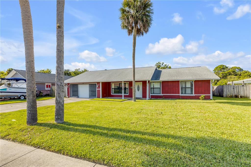 A red, single-story house with a gray roof and a palm tree in the yard — 709 TARRY TOWN TRAIL, PORT ORANGE, FL