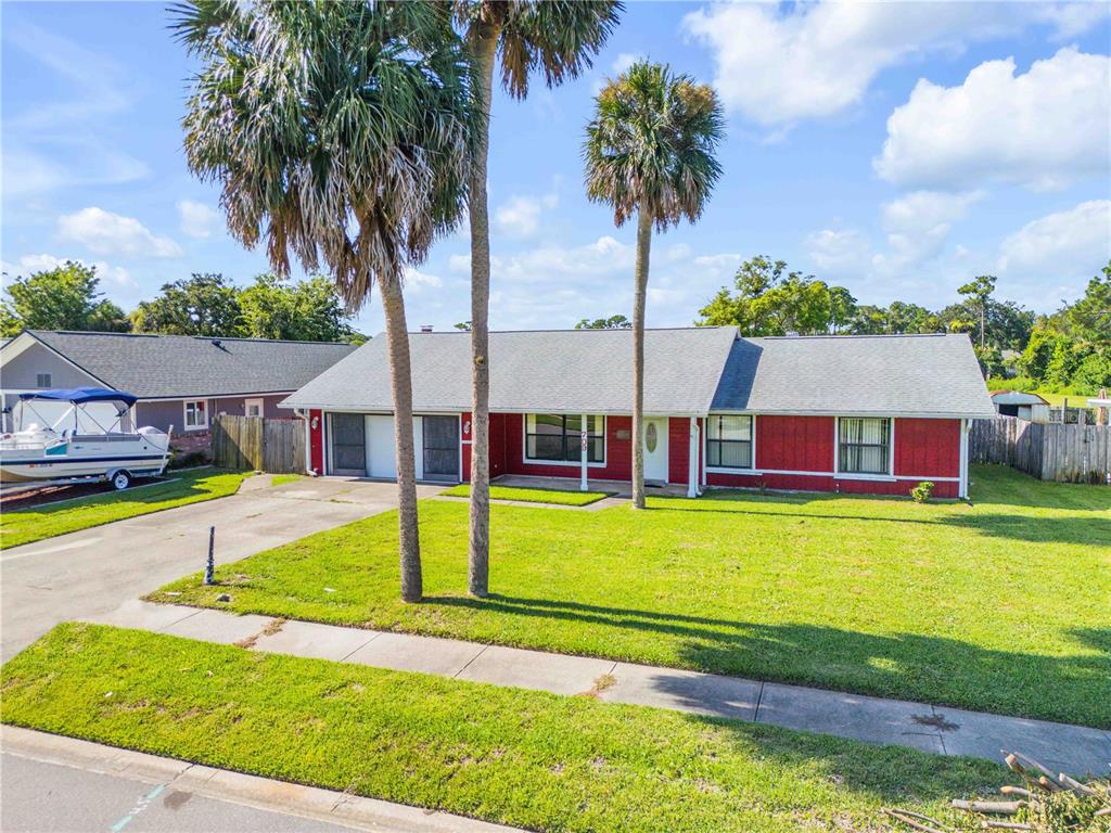 A red single-story house with a gray roof and two palm trees in the front yard — 709 TARRY TOWN TRAIL, PORT ORANGE, FL