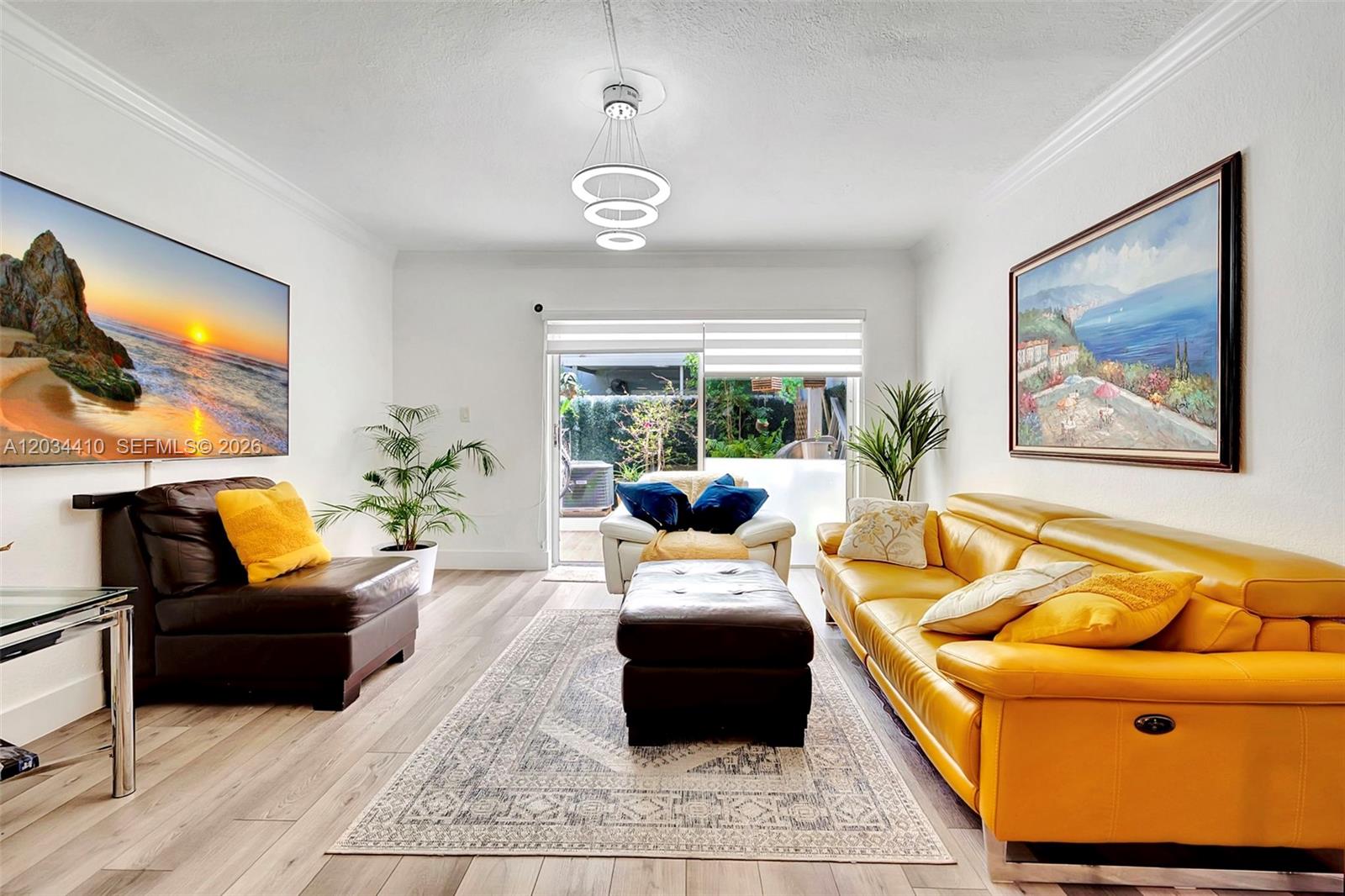 A living room features a yellow sofa, a brown chair, and a sliding glass door — 1187 NW 123rd Pl, Miami FL 33182, MIAMI, FL