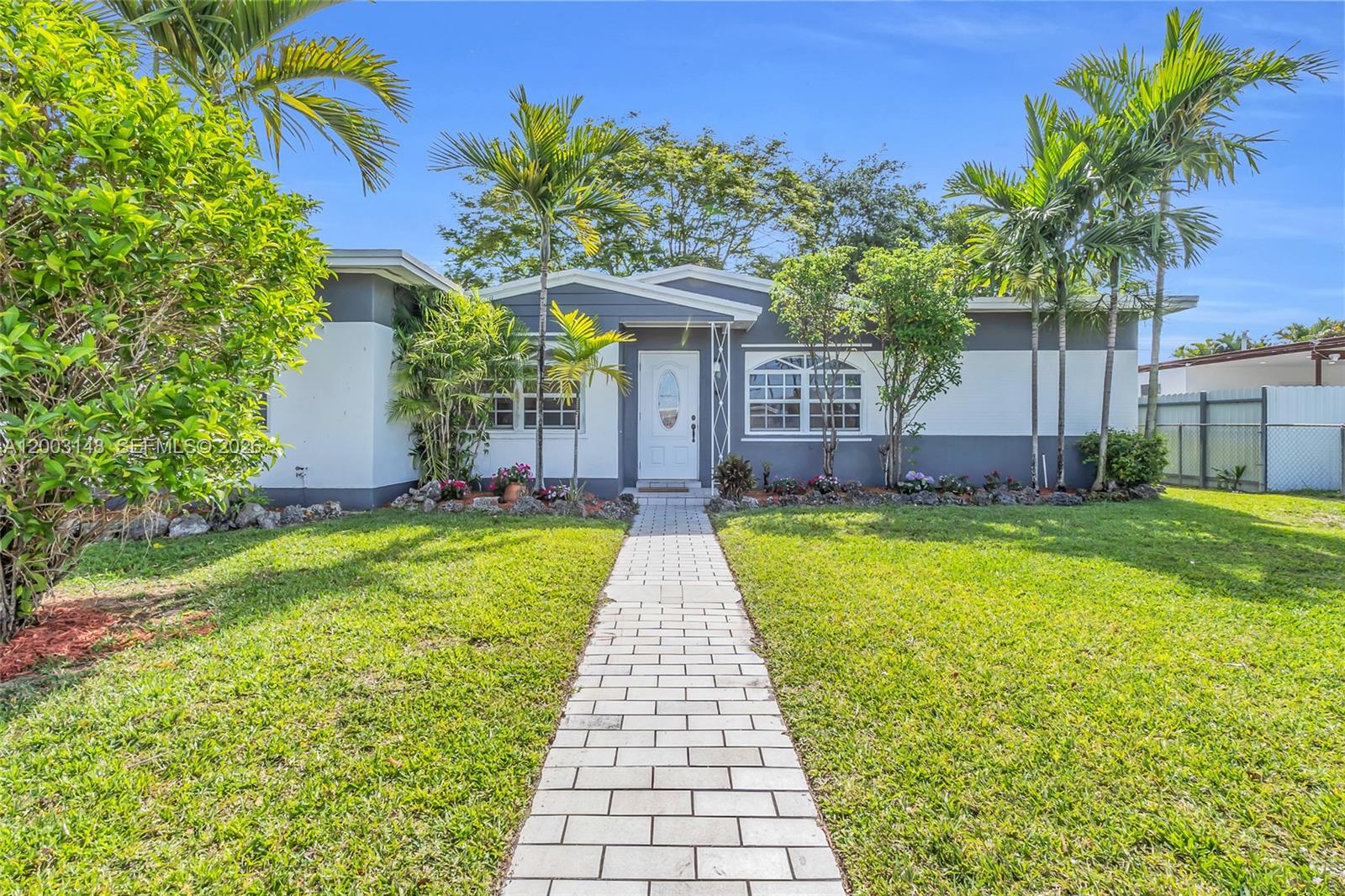 A single-story house with a white and gray exterior, a paved walkway, and palm trees — 5971 W 13th Ave, Hialeah FL 33012, HIALEAH, FL