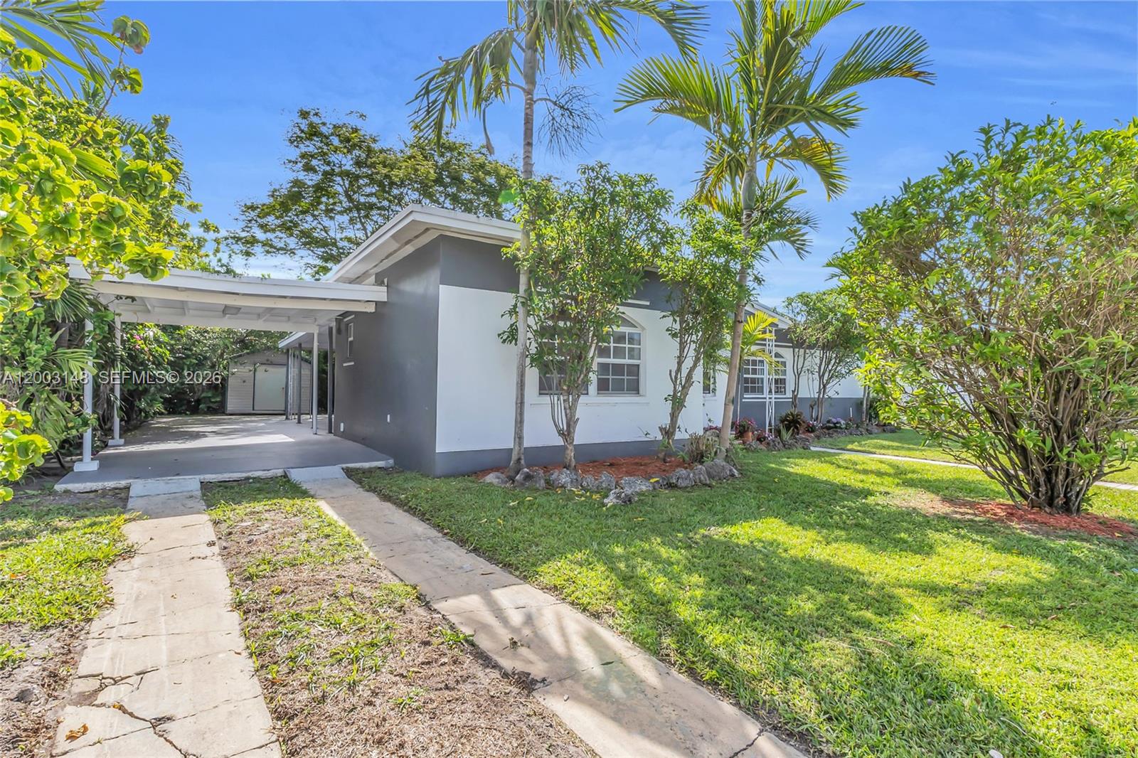A single-story house with a carport, gray and white exterior, and palm trees in front — 5971 W 13th Ave, Hialeah FL 33012, HIALEAH, FL