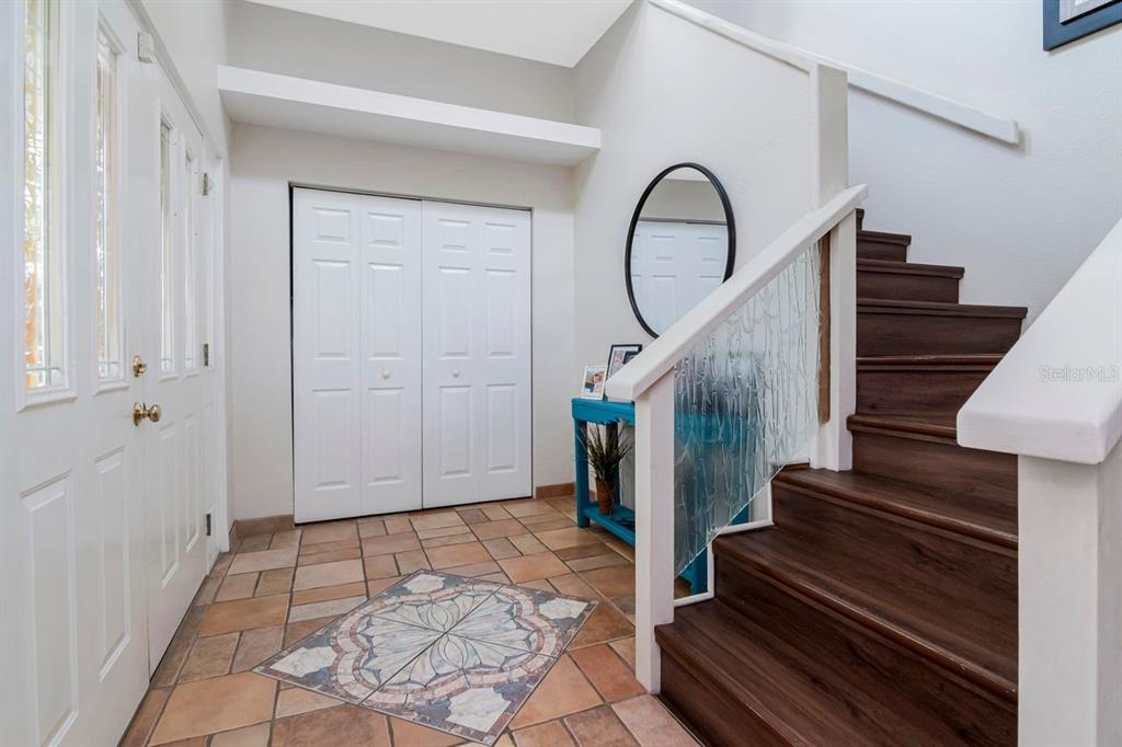 An entryway features tile flooring with a decorative inlay, a staircase, and a closet — 10532 67TH AVENUE, SEMINOLE, FL