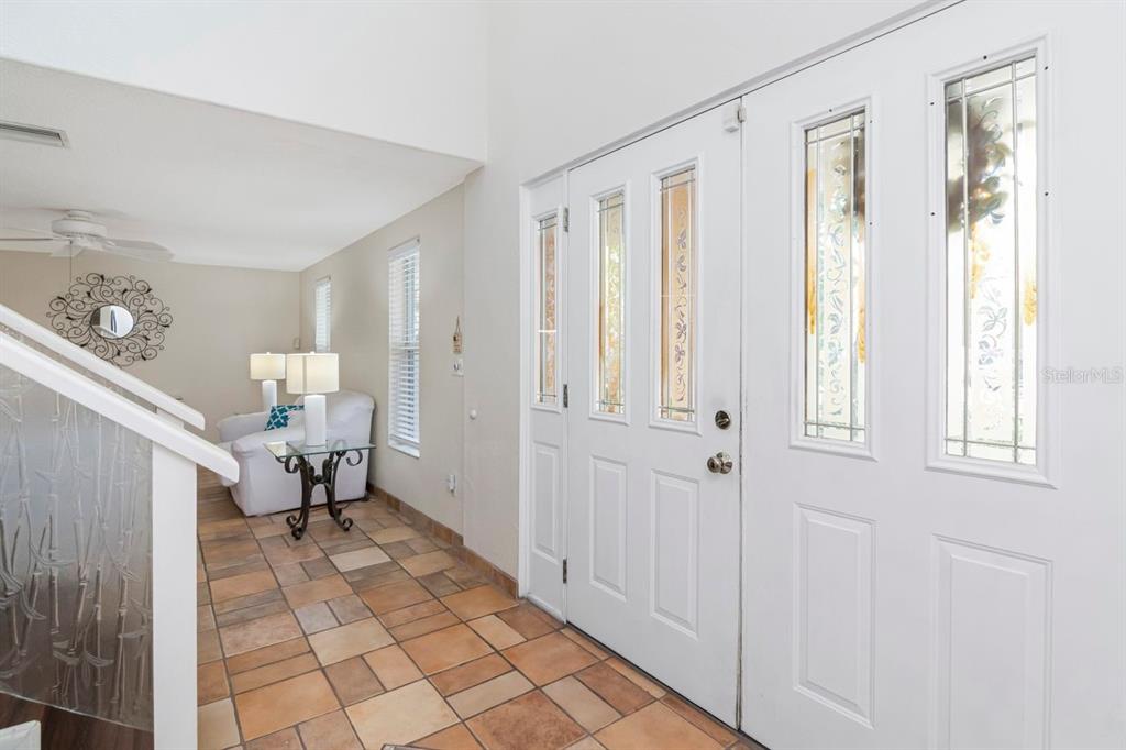 An entryway with tiled floors, a white front door with glass panels, and a staircase — 10532 67TH AVENUE, SEMINOLE, FL