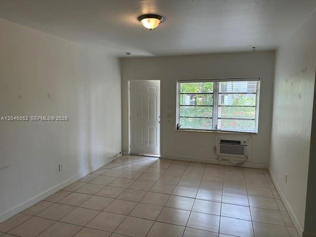 An empty room features white walls, a tiled floor, a window, and a door — 30 S Shore Dr # 4, Miami Beach FL 33141, MIAMI BEACH, FL