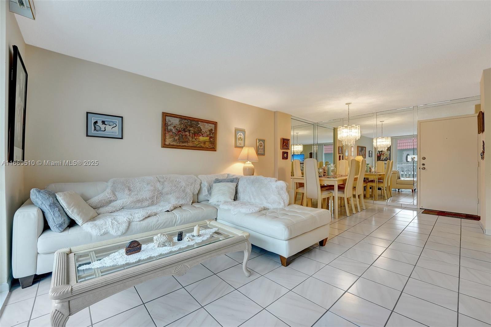A living room with white tile floors, a sectional sofa, and a mirrored dining area — 3113 S Ocean Dr # 402, Hallandale Beach FL 33009, HALLANDALE BEACH, FL