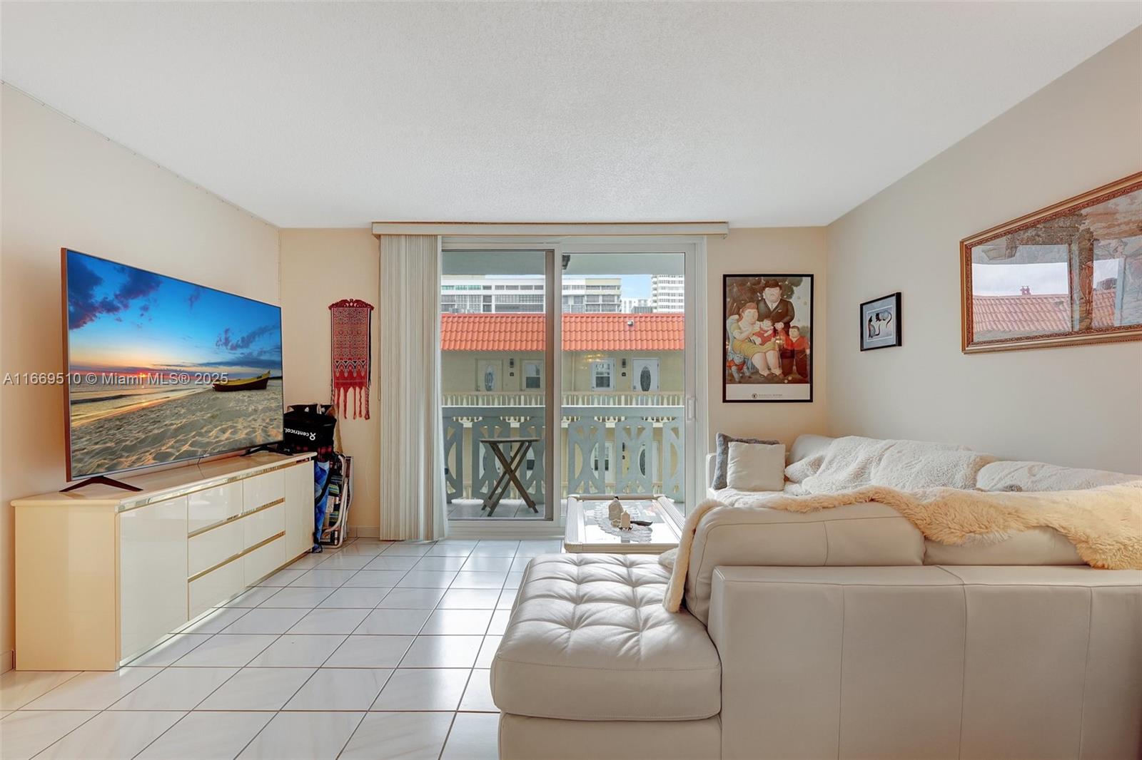 A living room features white tile floors, a large sectional sofa, and a sliding glass door — 3113 S Ocean Dr # 402, Hallandale Beach FL 33009, HALLANDALE BEACH, FL