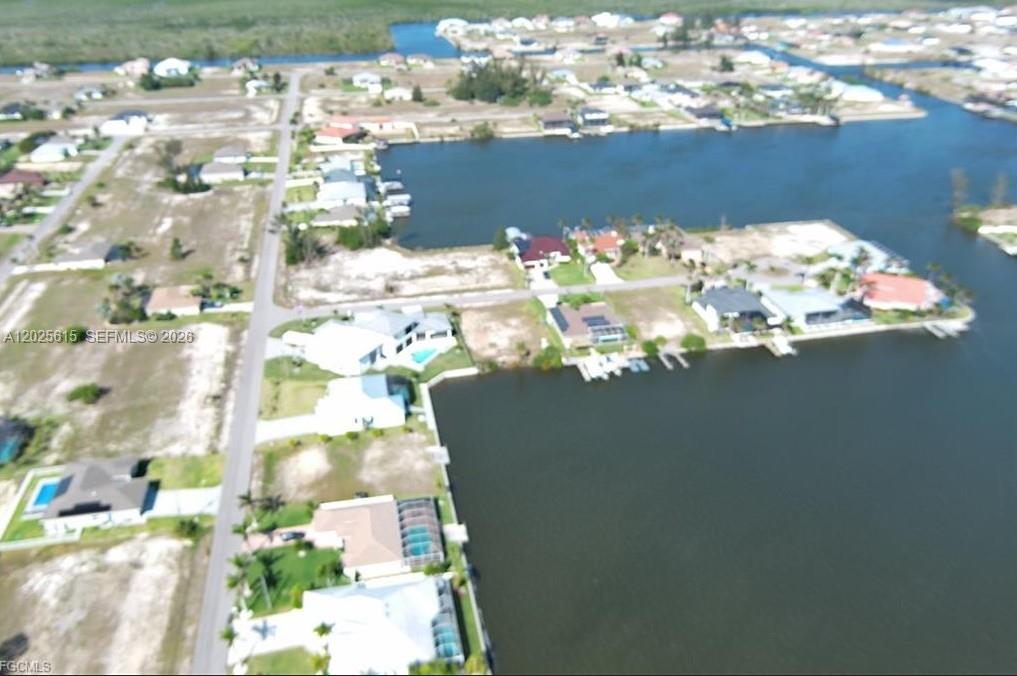 An aerial view shows waterfront houses along a canal in a residential neighborhood — CAPE CORAL, FL