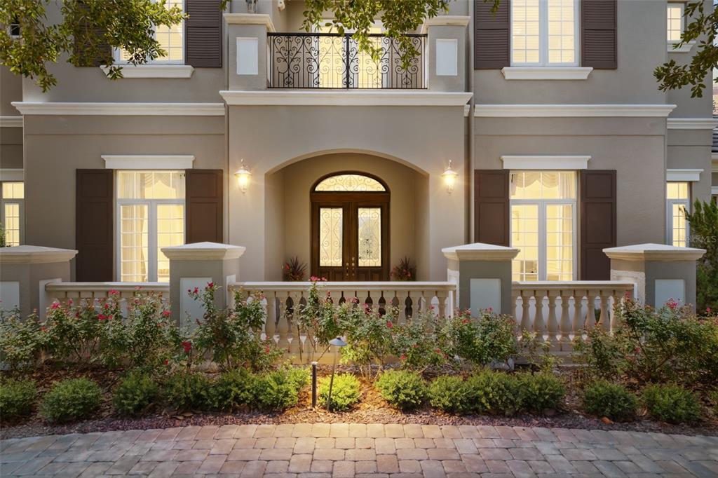 A two-story house exterior features a stone balustrade, arched entryway, and a wrought-iron balcony — 26010 ESTATES RIDGE DRIVE, SORRENTO, FL