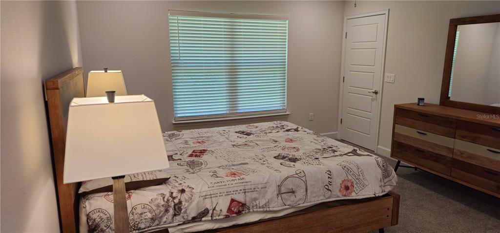 A bedroom features a bed with a Paris-themed comforter, a wooden dresser, and a window — 137 ULLIAN TRAIL, PALM COAST, FL