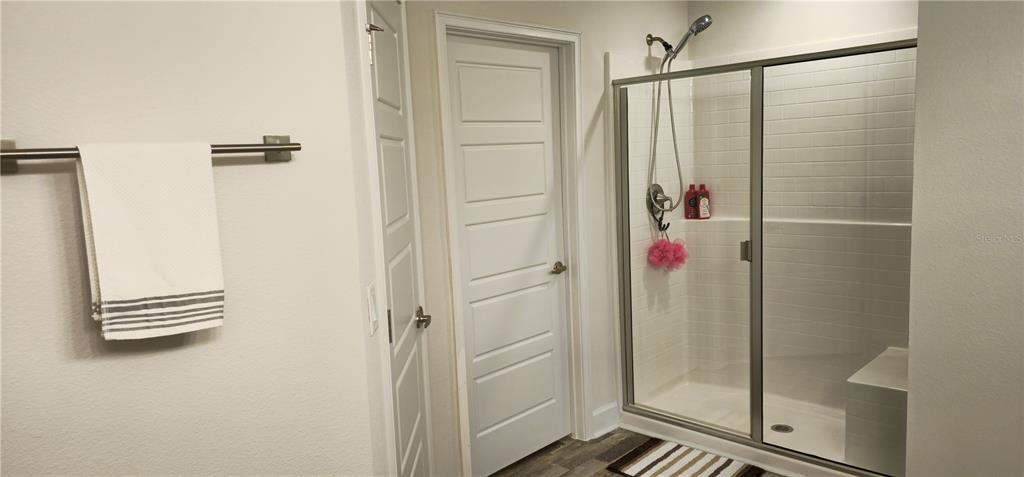 A bathroom features a walk-in shower with glass doors, a white door, and a towel rack — 137 ULLIAN TRAIL, PALM COAST, FL