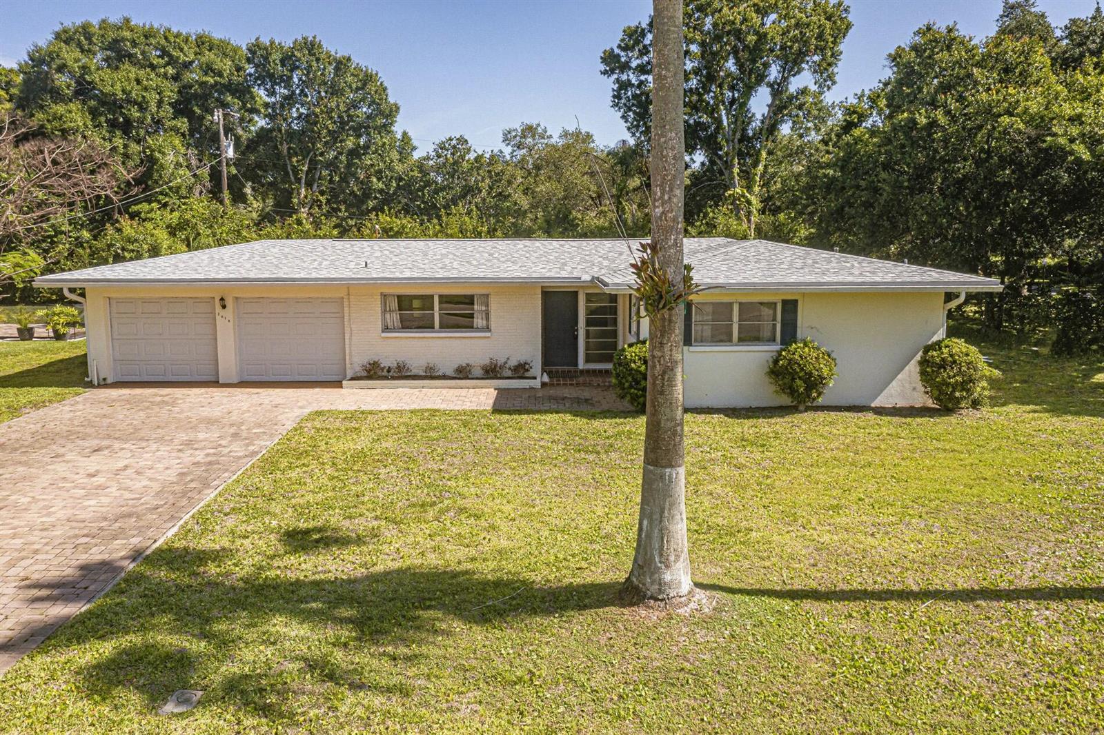 A single-story, light-colored brick house with a two-car garage and a paved driveway — 2616 15th Street, Vero Beach FL 32960, VERO BEACH, FL