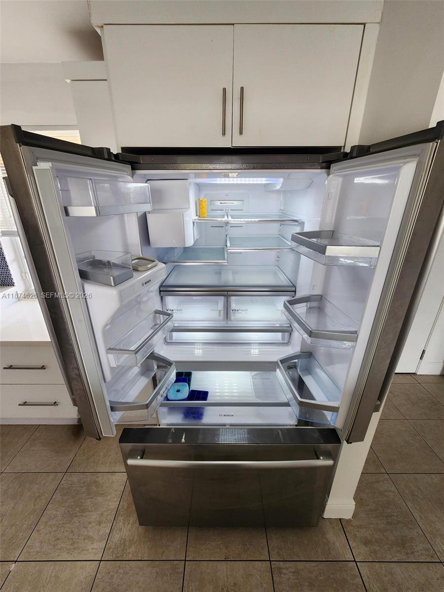 A stainless steel Bosch refrigerator with open doors is centered in a kitchen — 425 SE 11th Ter # 403, Dania Beach FL 33004, DANIA BEACH, FL