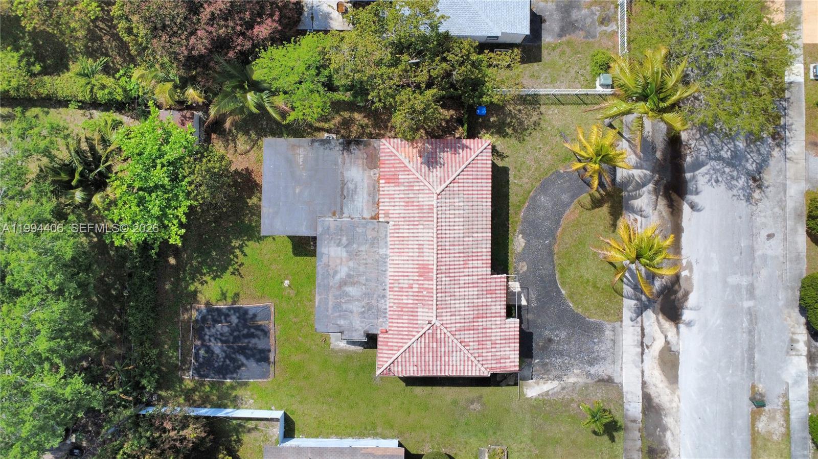 An aerial view shows a house with a red tile roof and a flat roof section — 12901 NW Miami Ct, Miami FL 33168, MIAMI, FL