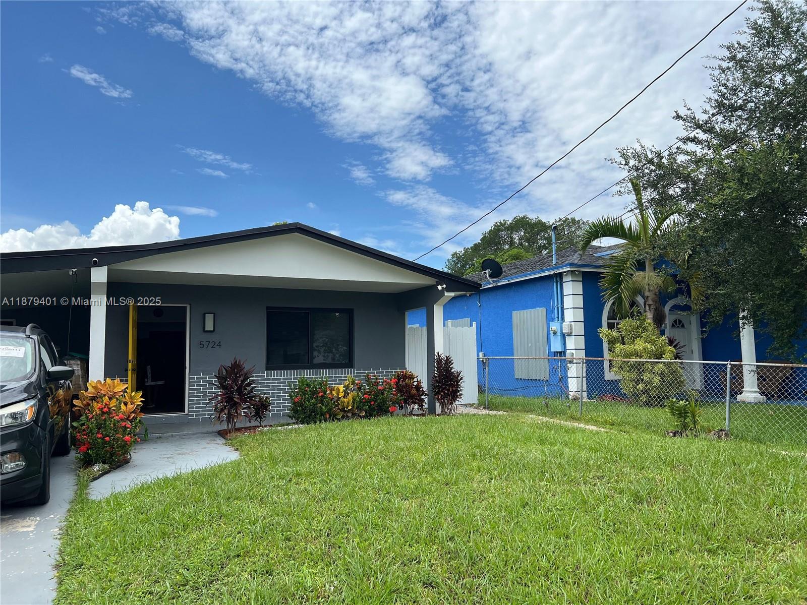 A gray house with a covered porch and a blue house sit side-by-side — 5724 SW 18th St, West Park FL 33023, WEST PARK, FL