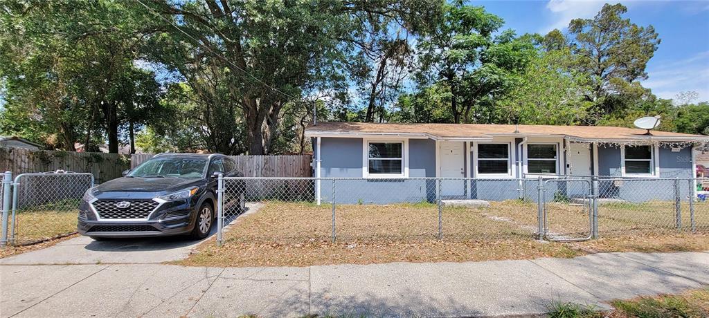 A gray single-story house with a chain-link fence and a parked car in the driveway — 1308 E YUKON STREET UNIT B, TAMPA, FL