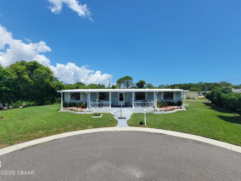 A light blue single-story house features a front porch, white railings, and a landscaped yard — 734 SHELDON CIRCLE, PORT ORANGE, FL
