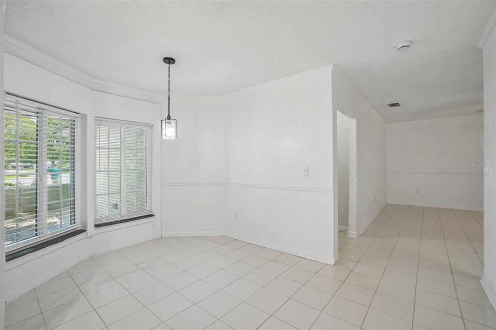 A dining area with white walls, tile flooring, a bay window, and a pendant light — 222 LAKEVIEW DRIVE, AUBURNDALE, FL