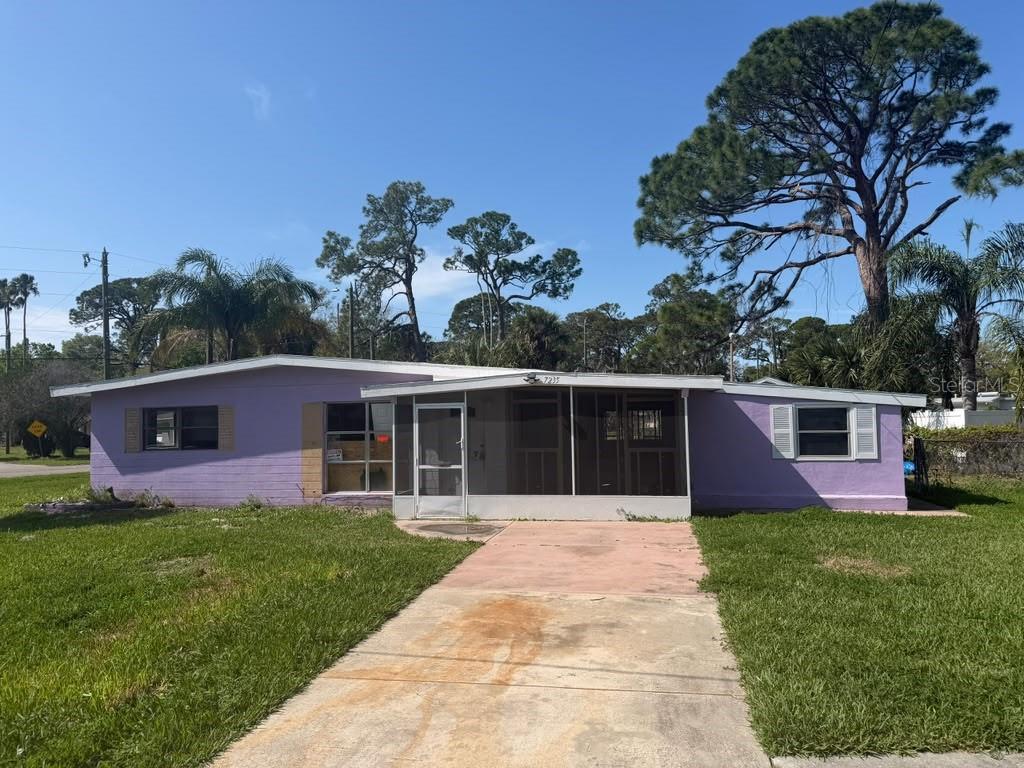 A single-story purple house with a screened-in front porch and a concrete driveway — 7235 ROYAL PALM DRIVE, NEW PORT RICHEY, FL