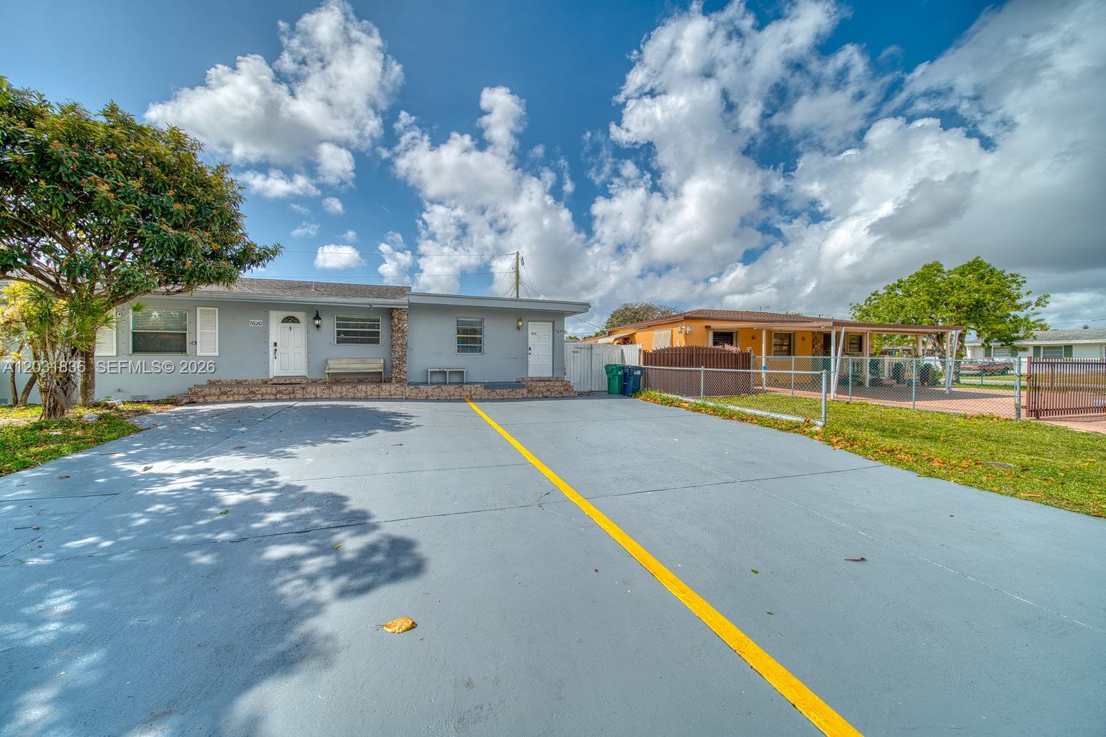 A gray house with a large paved driveway and a yellow painted dividing line — 7622 SW 21st St # 7622, Miami FL 33155, MIAMI, FL