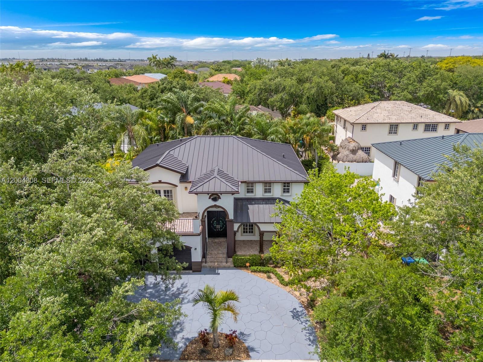 An aerial view of a two-story house with a dark metal roof and paved driveway — 16230 NW 84th Ct, Miami Lakes FL 33016, MIAMI LAKES, FL