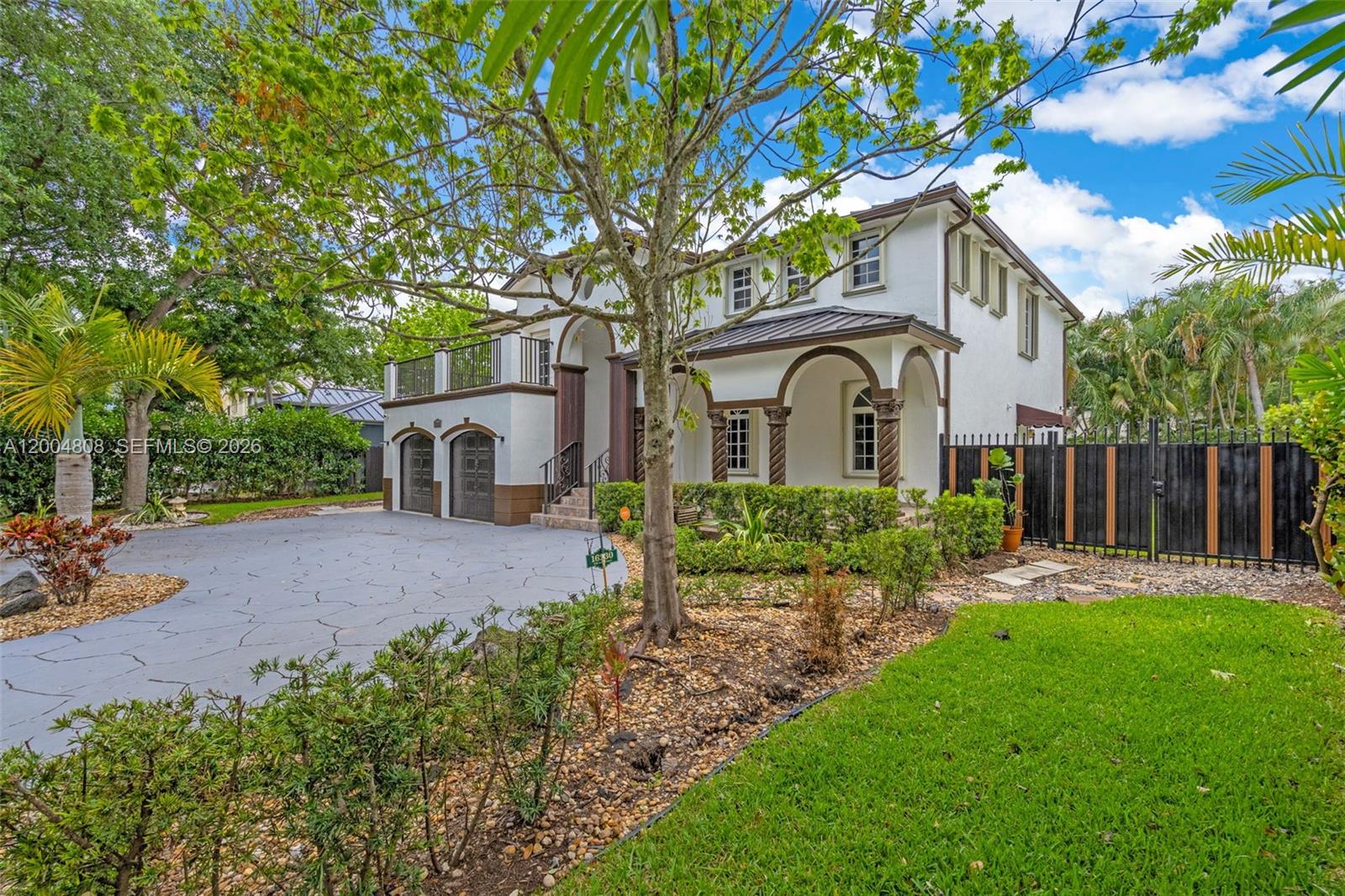 A two-story house with a white stucco facade, arched entryway, and a paved driveway — 16230 NW 84th Ct, Miami Lakes FL 33016, MIAMI LAKES, FL