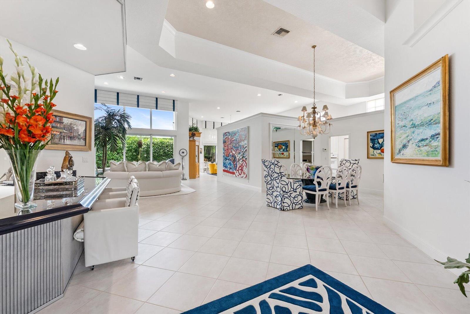 A spacious, open-concept living and dining area features white tile floors and high vaulted ceilings — 6533 Somerset Circle, Boca Raton FL 33496, BOCA RATON, FL