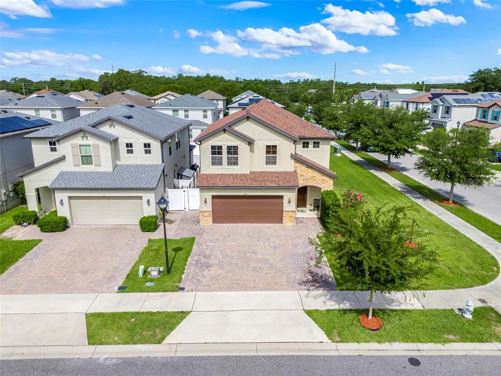 An aerial view shows two adjacent two-story suburban houses with paved driveways and lawns — 2948 CREST DRIVE, KISSIMMEE, FL