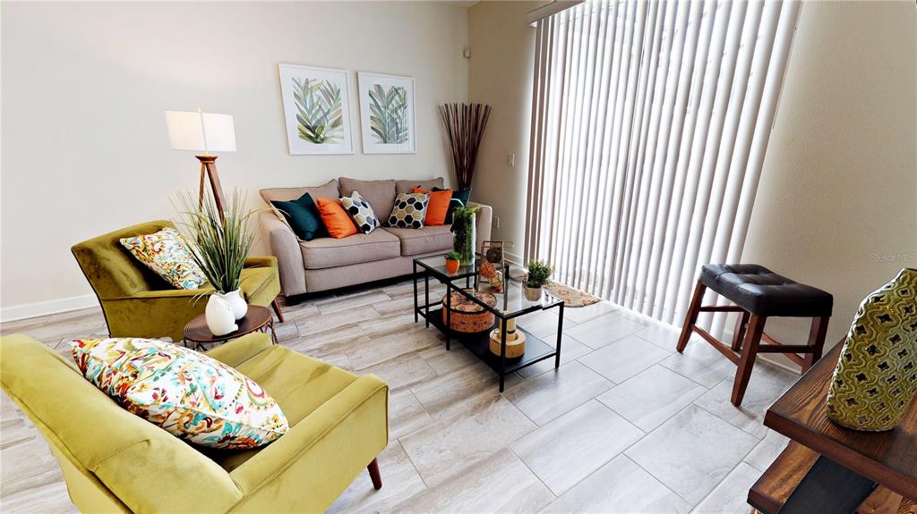 A living room features a beige sofa, two olive green armchairs, and tile flooring — 3083 TOM SAWYER DRIVE, KISSIMMEE, FL