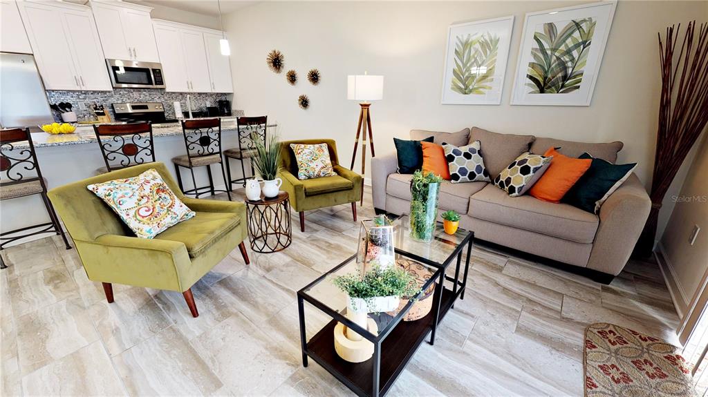 A living room with a beige sofa, two green armchairs, and a glass coffee table — 3083 TOM SAWYER DRIVE, KISSIMMEE, FL