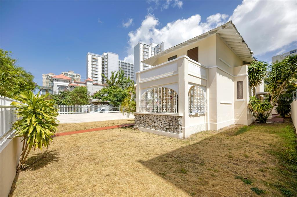 The exterior of a two-story house features a stone-based porch with white decorative metal grilles — 1430 WILSON STREET, SAN JUAN, PR