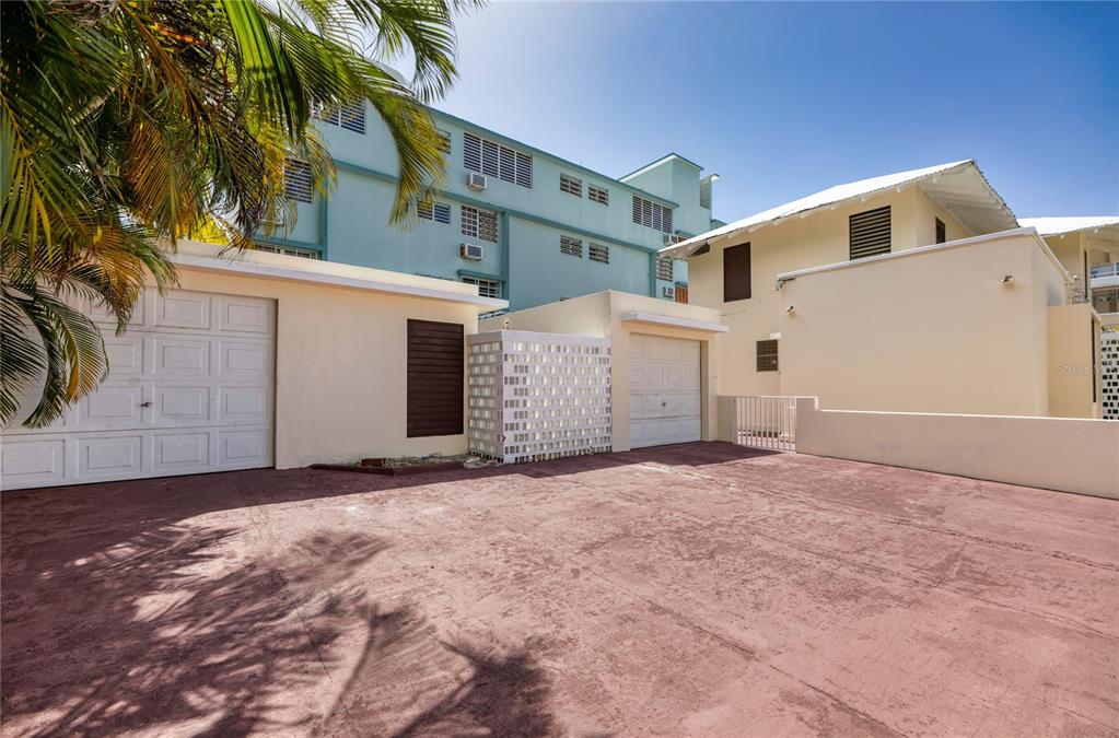 A paved driveway sits in front of two garages and a multi-story building — 1430 WILSON STREET, SAN JUAN, PR