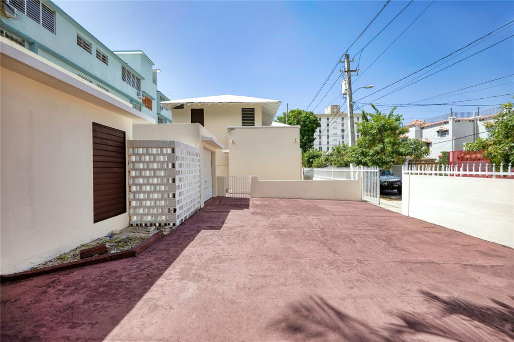 A paved driveway leads to a white building with a garage and a privacy wall — 1430 WILSON STREET, SAN JUAN, PR