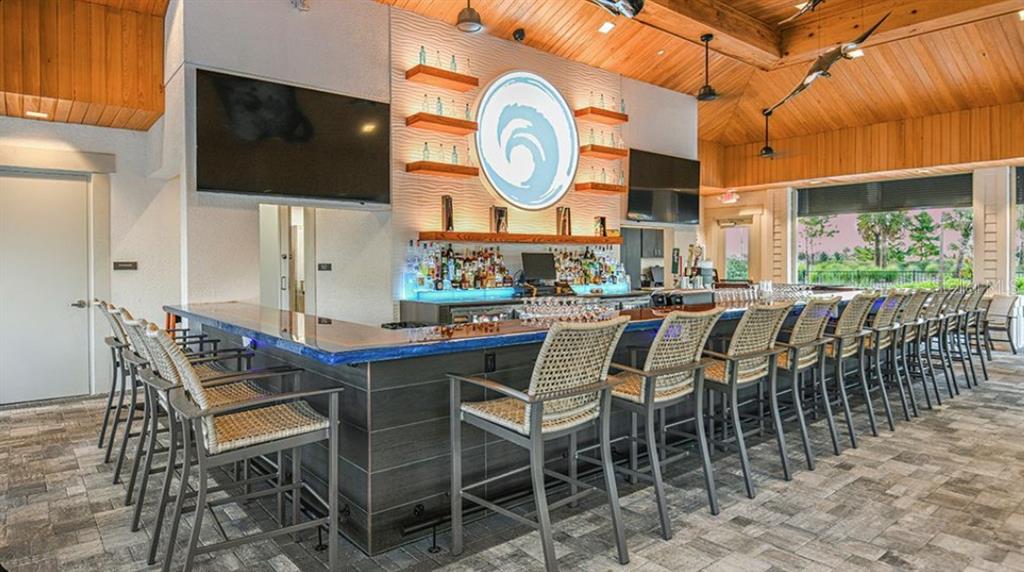 A modern kitchen features white cabinetry, a large central island, and wood-look flooring — 13827 BUCHANAN DRIVE, PALMETTO, FL
