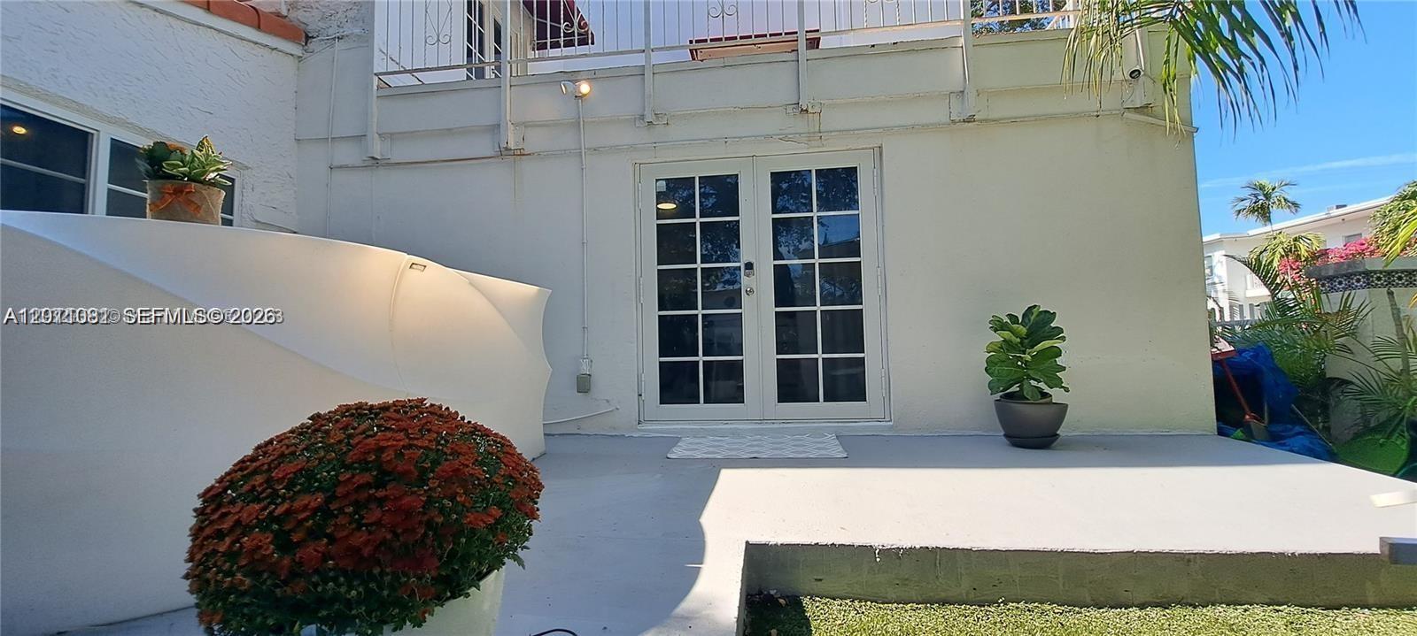 A patio features a set of French doors, potted plants, and a white privacy screen — 846 Michigan Ave # 101, Miami Beach FL 33139, MIAMI BEACH, FL