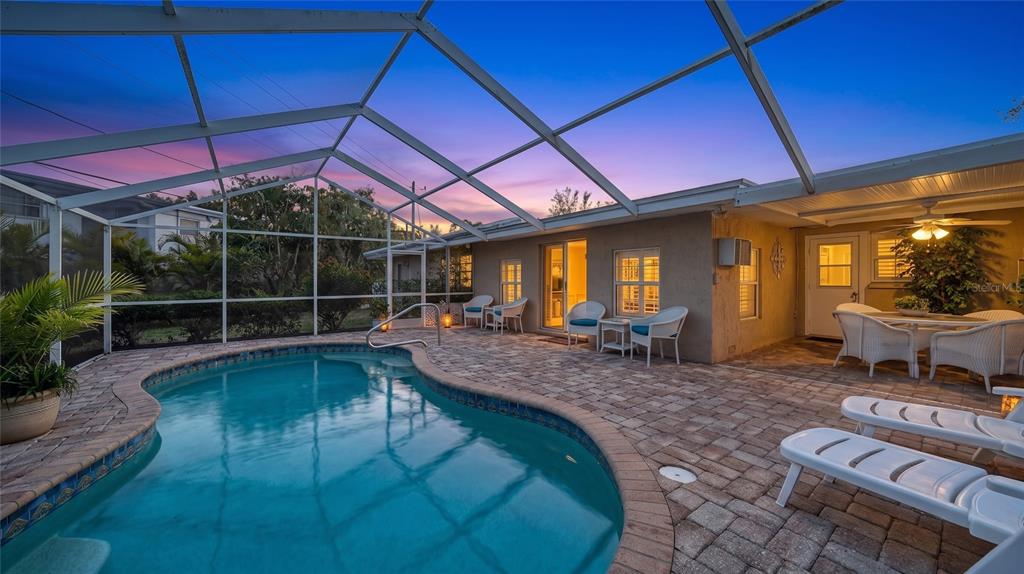A screened-in patio features a kidney-shaped swimming pool, paver deck, and outdoor dining area — 3537 S SCHOOL AVENUE, SARASOTA, FL