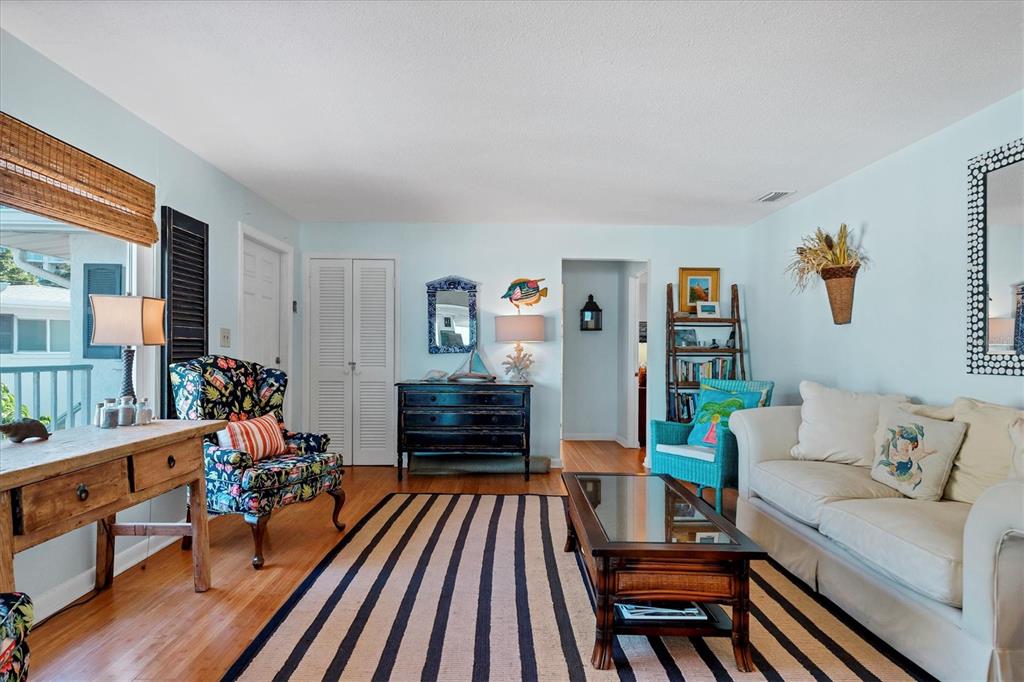A living room features light blue walls, a striped rug, and a white sofa — 1336 BENJAMIN FRANKLIN DRIVE UNIT F2, SARASOTA, FL